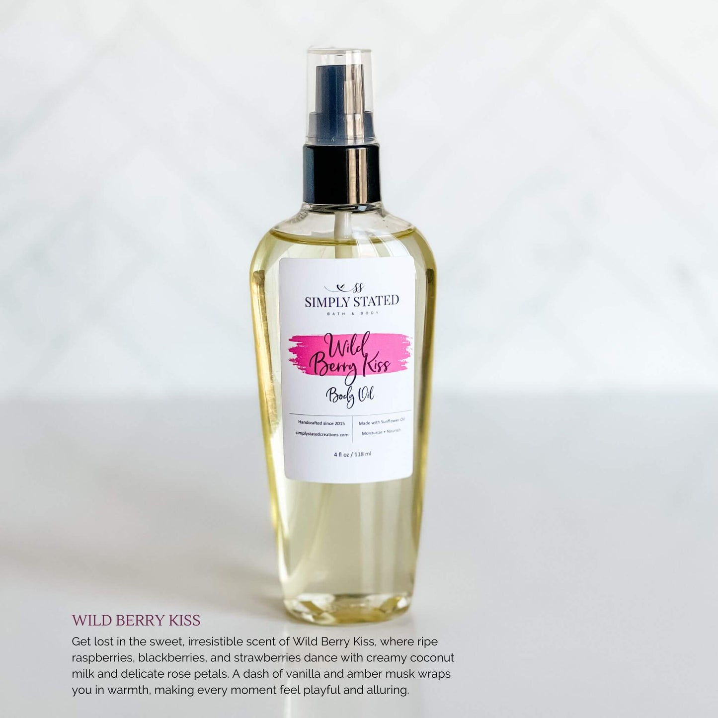 Simply Stated Bath & Body Wild Berry Kiss Body Oil in a glass spray bottle, featuring a magenta label, displayed on a white surface.