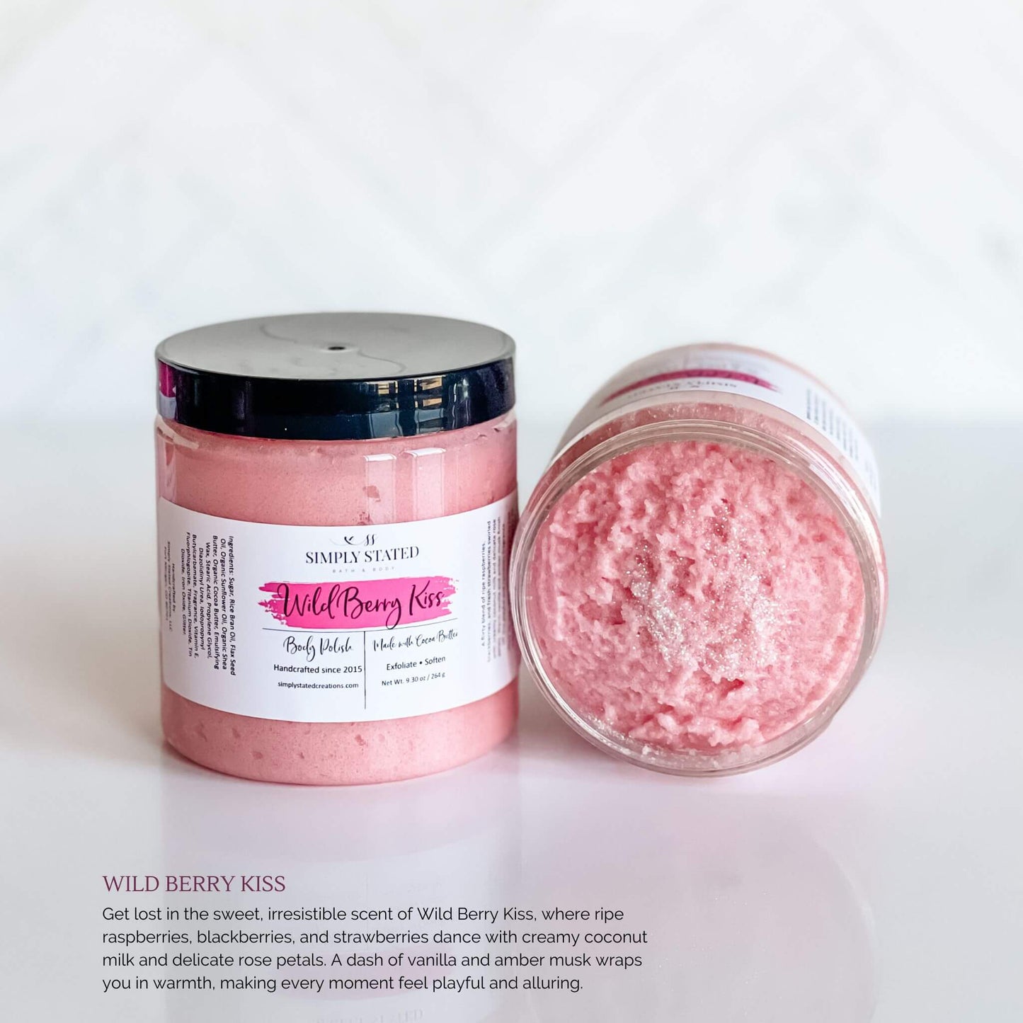 Simply Stated Bath & Body Wild Berry Kiss Body Polish in a jar with soft pink whipped exfoliating scrub, featuring a magenta label and black lid, displayed on a white background.