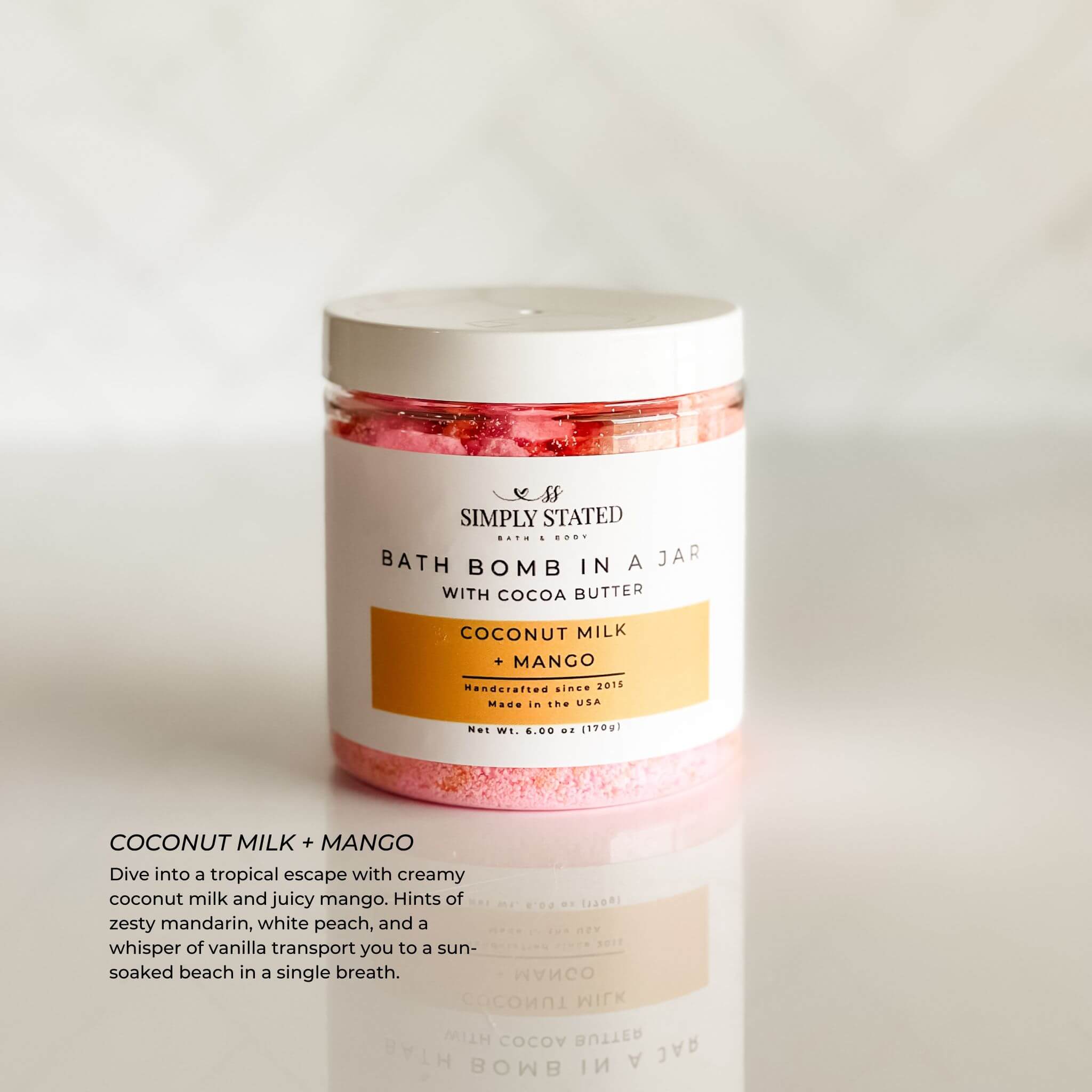 Simply Stated Bath & Body Signature Line Bath Bomb in a Jar - Coconut Milk + Mango. A tropical blend of creamy coconut milk and juicy mango in a luxurious bath bomb powder, handcrafted for a relaxing and moisturizing soak.