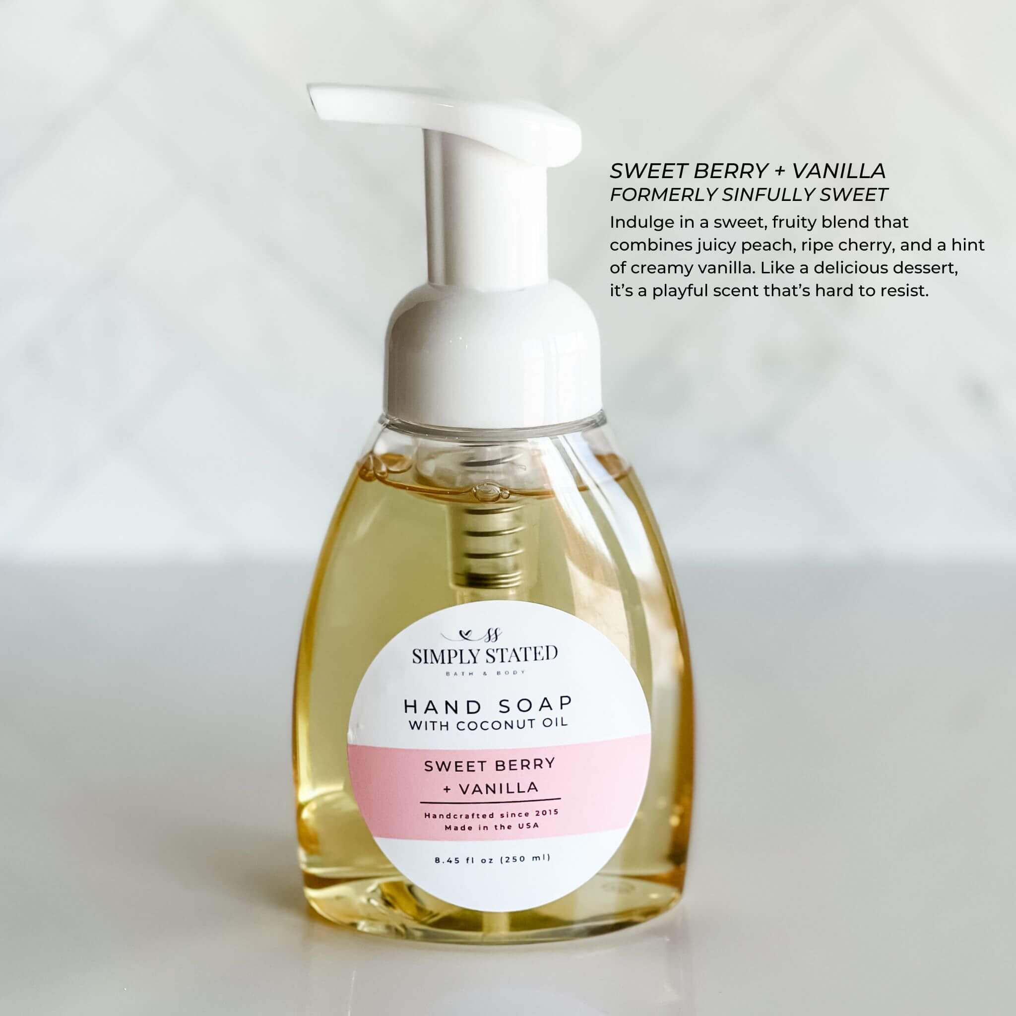 Simply Stated Bath & Body Sweet Berry + Vanilla Hand Soap in a soft pink hue, housed in an 8oz pump bottle. A playful fruity blend with peach, cherry, and vanilla notes.