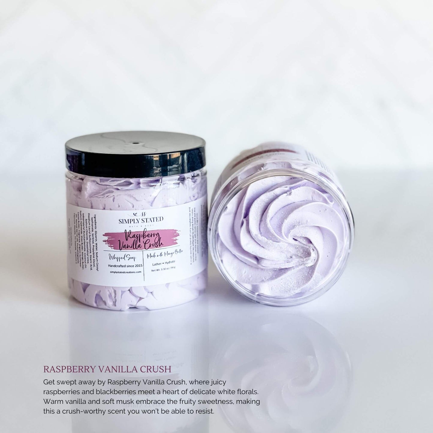 Simply Stated Bath & Body Raspberry Vanilla Crush Whipped Soap in a clear jar with light purple swirled soap, featuring a purple label and black lid, displayed on a white background.