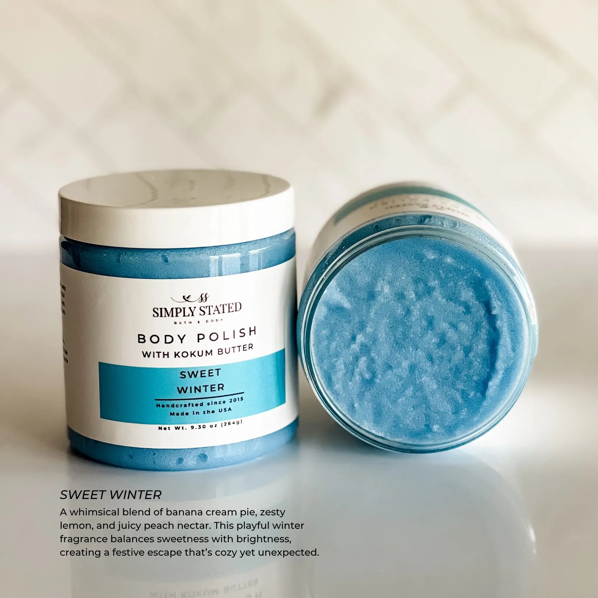 Body polish jar with lid off, showing blue scrub, on a light background